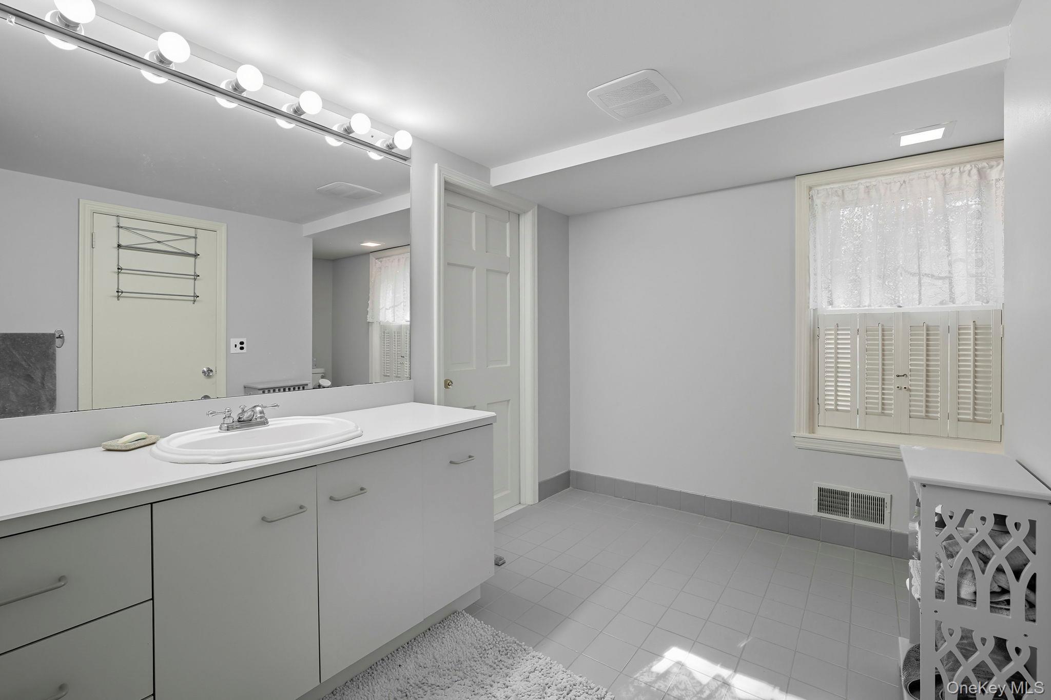 122 Harriman Road Mount Kisco, NY 10549 - Photo 25 of 39 a spacious bathroom with a double vanity sink and a mirror