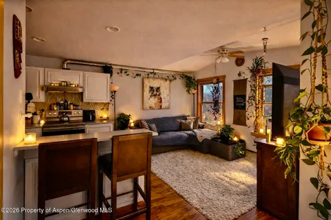 a room with lots of potted plants and wooden floor