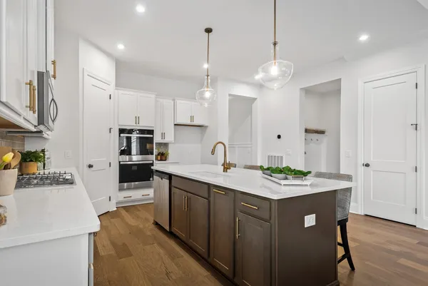 a kitchen with a sink a refrigerator and white cabinets
