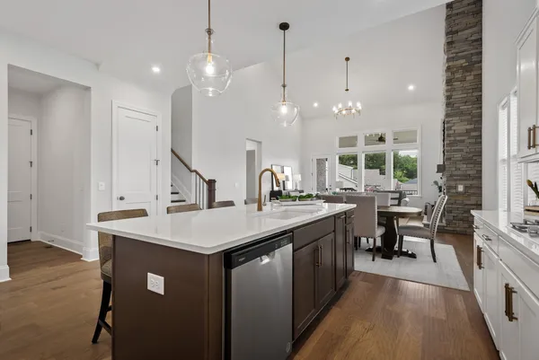 a kitchen with kitchen island a sink a counter space appliances and a living room view
