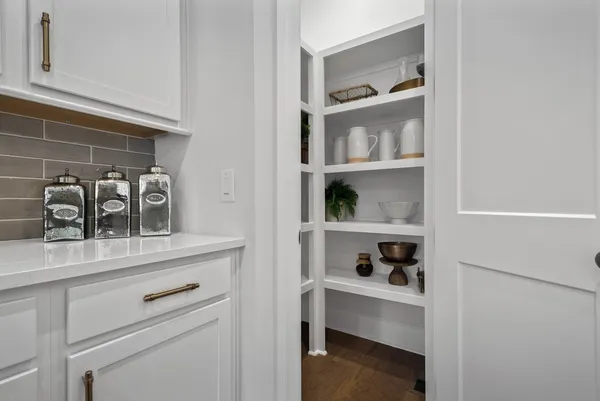 a view of white cabinets and a table with wooden floor