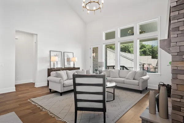 a living room with furniture and floor to ceiling windows