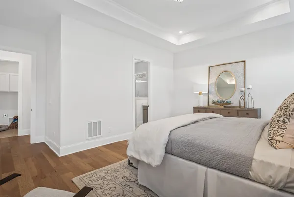 a bedroom with a bed and wooden floor