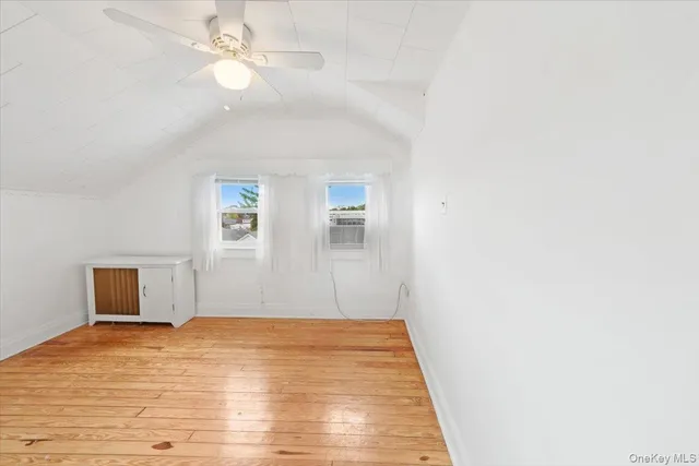 a view of empty room with wooden floor and ceiling fan