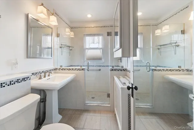 a bathroom with a sink a toilet and shower