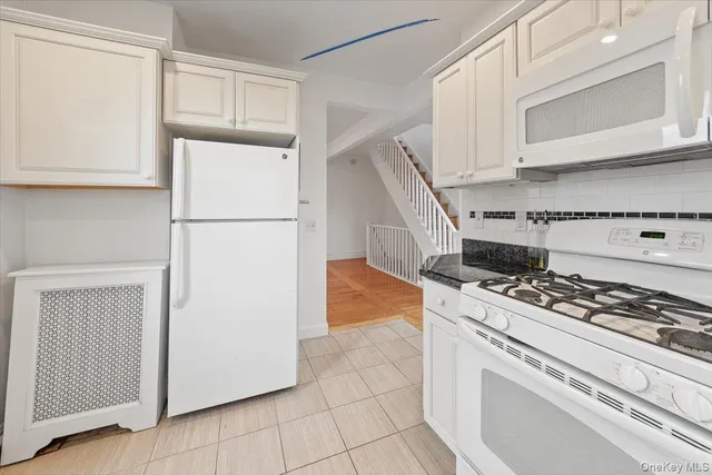 a kitchen with white cabinets and white appliances