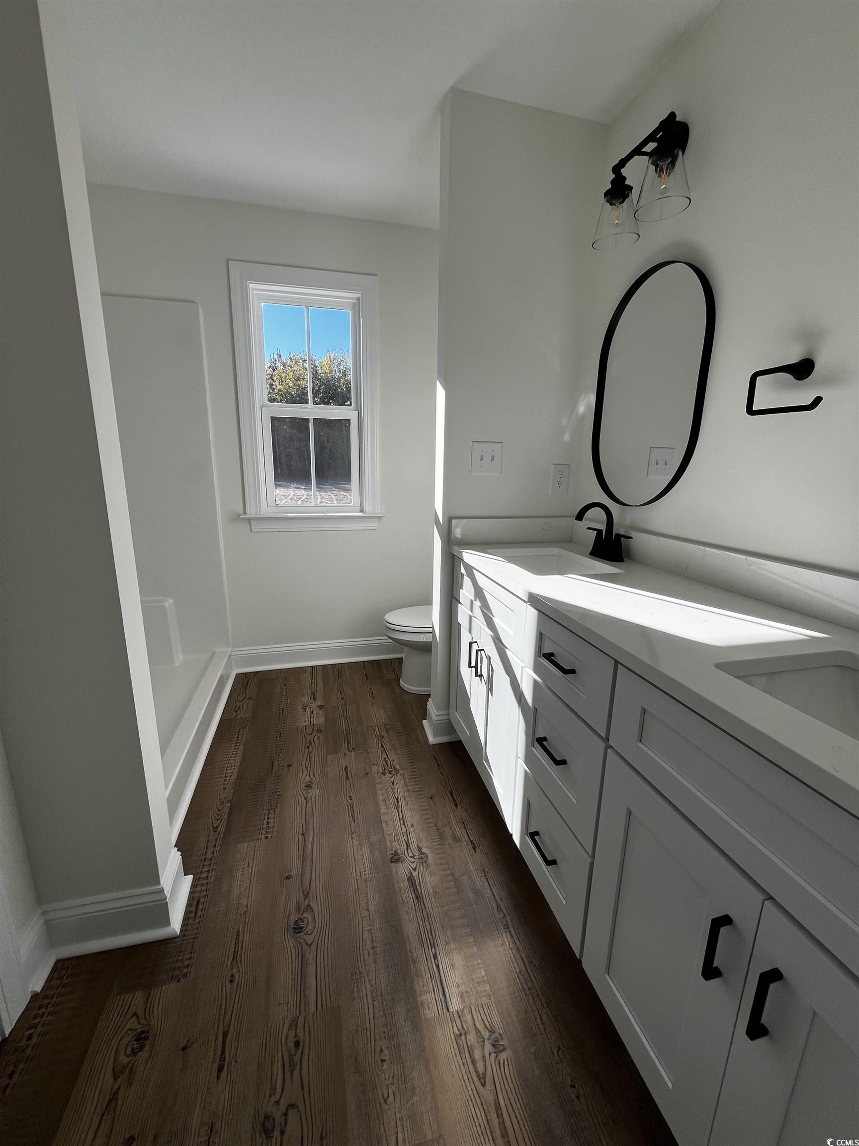 3440 Asbury Road Aynor, SC 29511 - Photo 5 of 9 Bathroom with double vanity, dark wood finished floors, and a stall shower