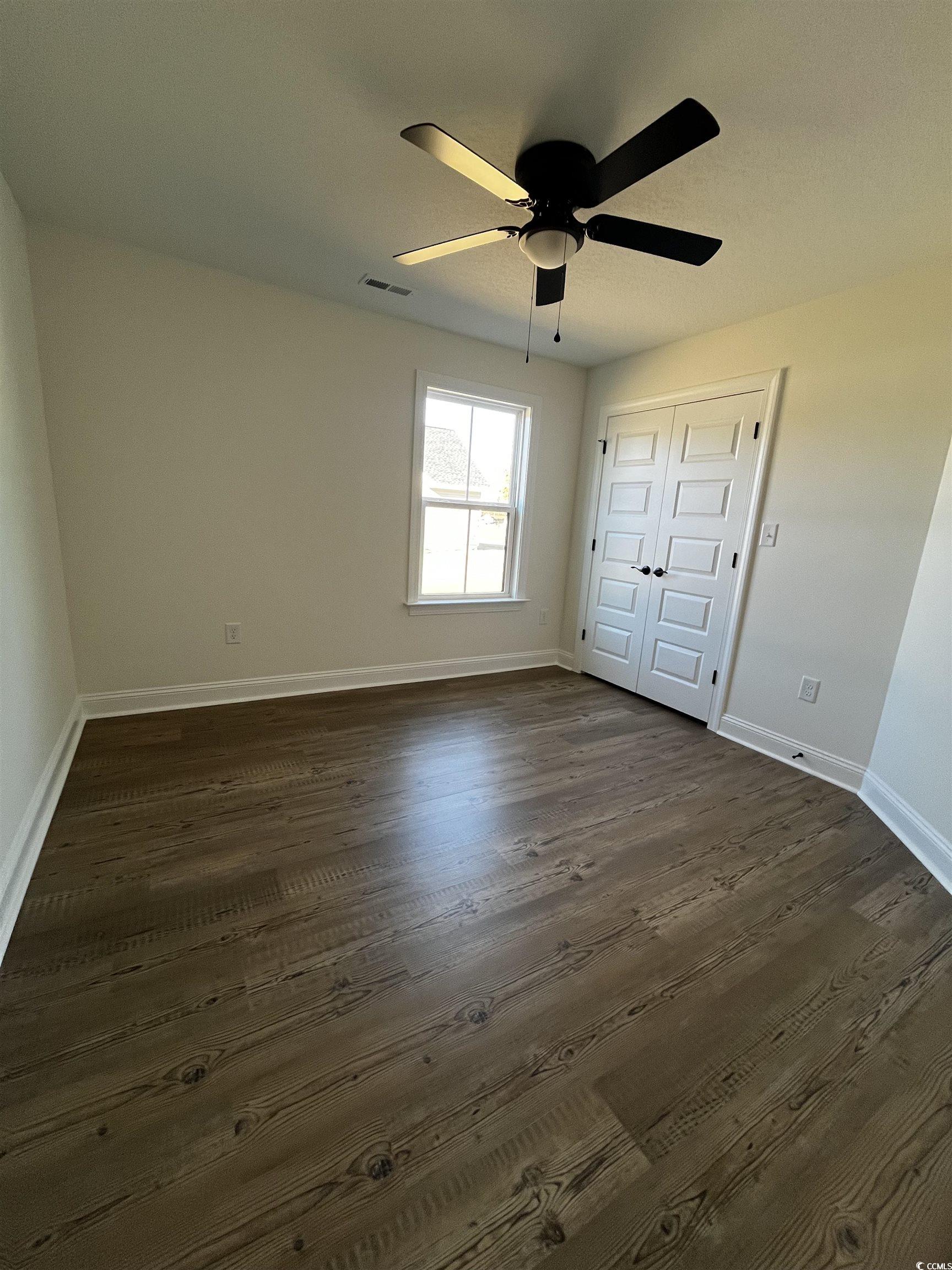 3440 Asbury Road Aynor, SC 29511 - Photo 7 of 9 Unfurnished bedroom with a closet, a ceiling fan, and dark wood-style flooring