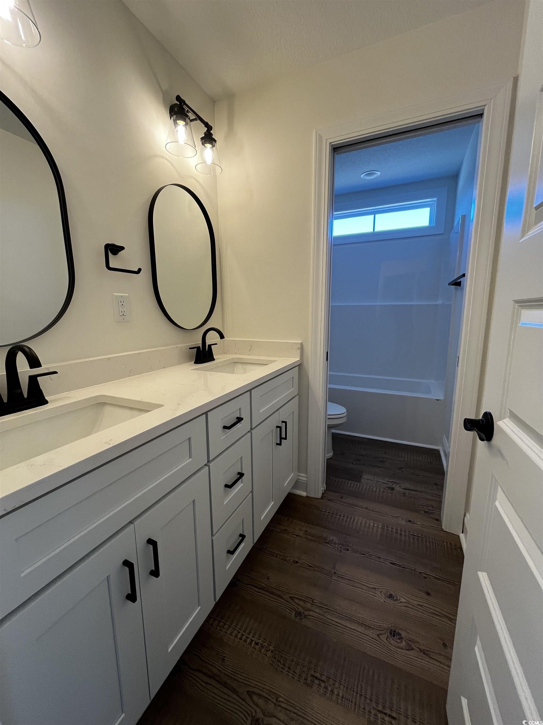 3440 Asbury Road Aynor, SC 29511 - Photo 8 of 9 Bathroom with double vanity, dark wood-style floors, and shower / washtub combination