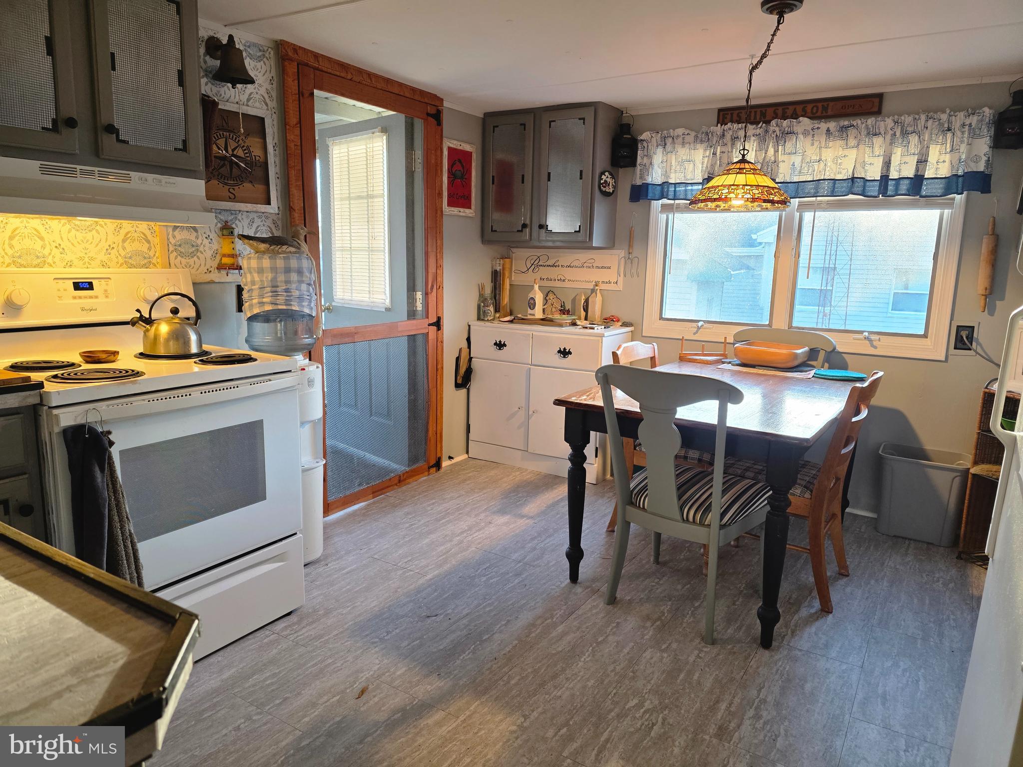 21 Vassar Avenue Fortescue, NJ 08321 - Photo 12 of 44 a kitchen with stainless steel appliances granite countertop a stove a sink dishwasher a dining table and chairs with wooden floor