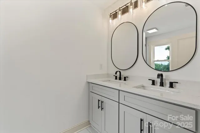 a bathroom with a granite countertop double vanity sink and a mirror
