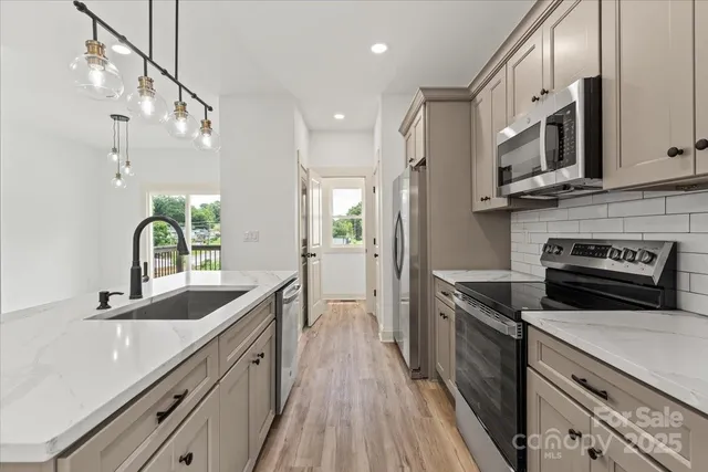 a kitchen with stainless steel appliances a sink stove and refrigerator