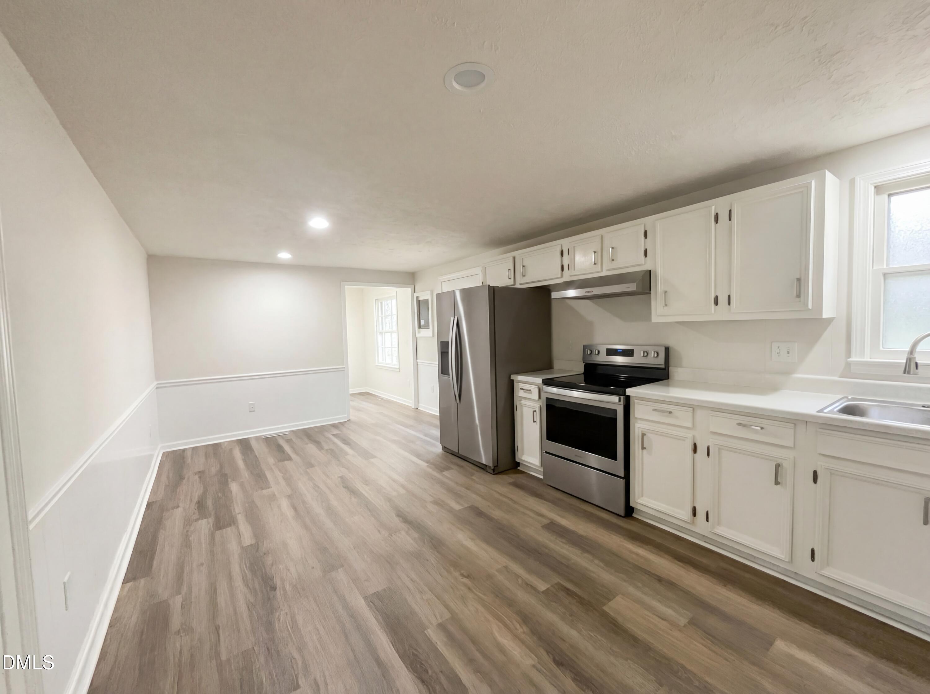 9815 Berry Road Timberlake, NC 27583 - Photo 5 of 17 a kitchen with granite countertop a refrigerator oven a sink and dishwasher with wooden floor