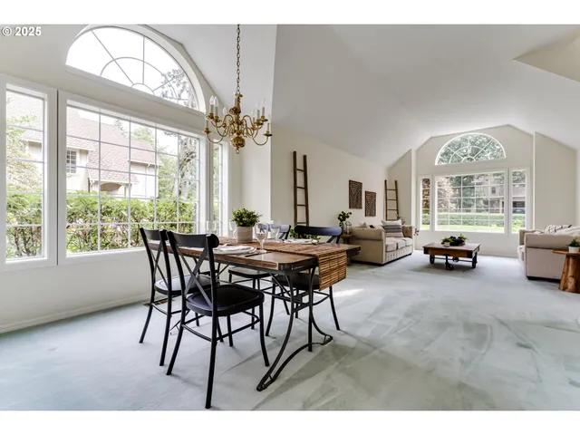 a view of a livingroom and a dining room with furniture a chandelier and wooden floor