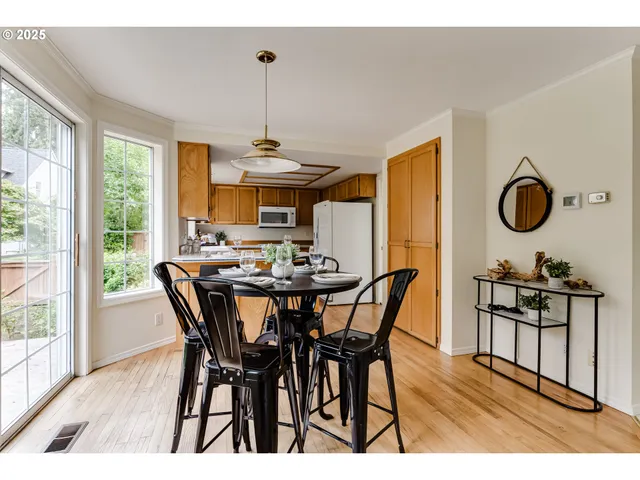 a view of a dining room and livingroom with furniture wooden floor a chandelier