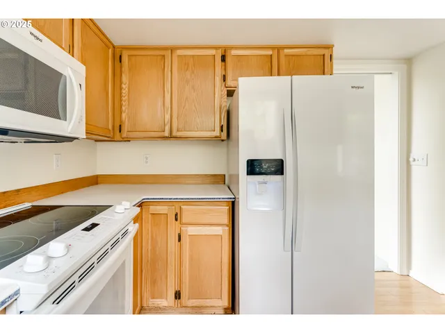 a kitchen with a refrigerator sink and cabinets