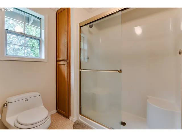 a bathroom with a toilet and a shower