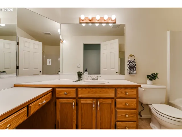 a bathroom with a sink a toilet and a mirror