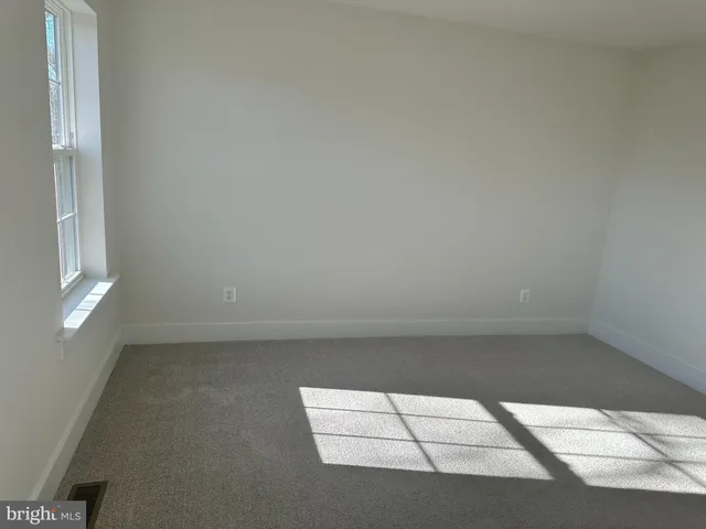 a view of a hallway with a livingroom and a window