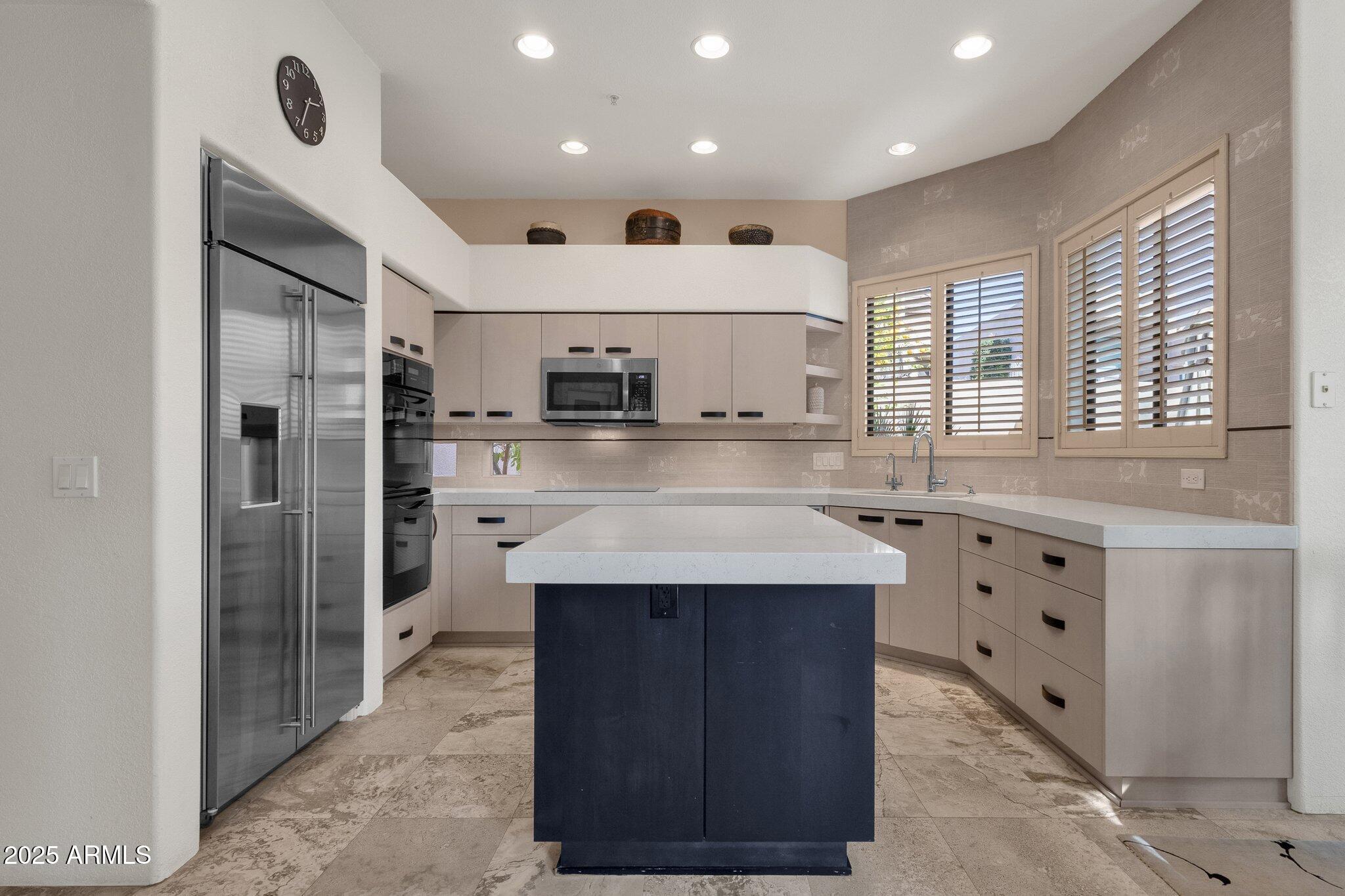 7740 East Gainey Ranch Road, Unit 36 Scottsdale, AZ 85258 - Photo 11 of 54 a kitchen with stainless steel appliances kitchen island granite countertop a sink and a refrigerator