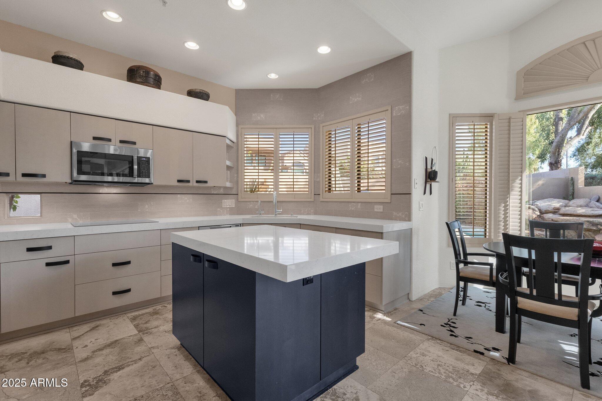 7740 East Gainey Ranch Road, Unit 36 Scottsdale, AZ 85258 - Photo 12 of 54 a kitchen with kitchen island granite countertop a sink counter top space and stainless steel appliances