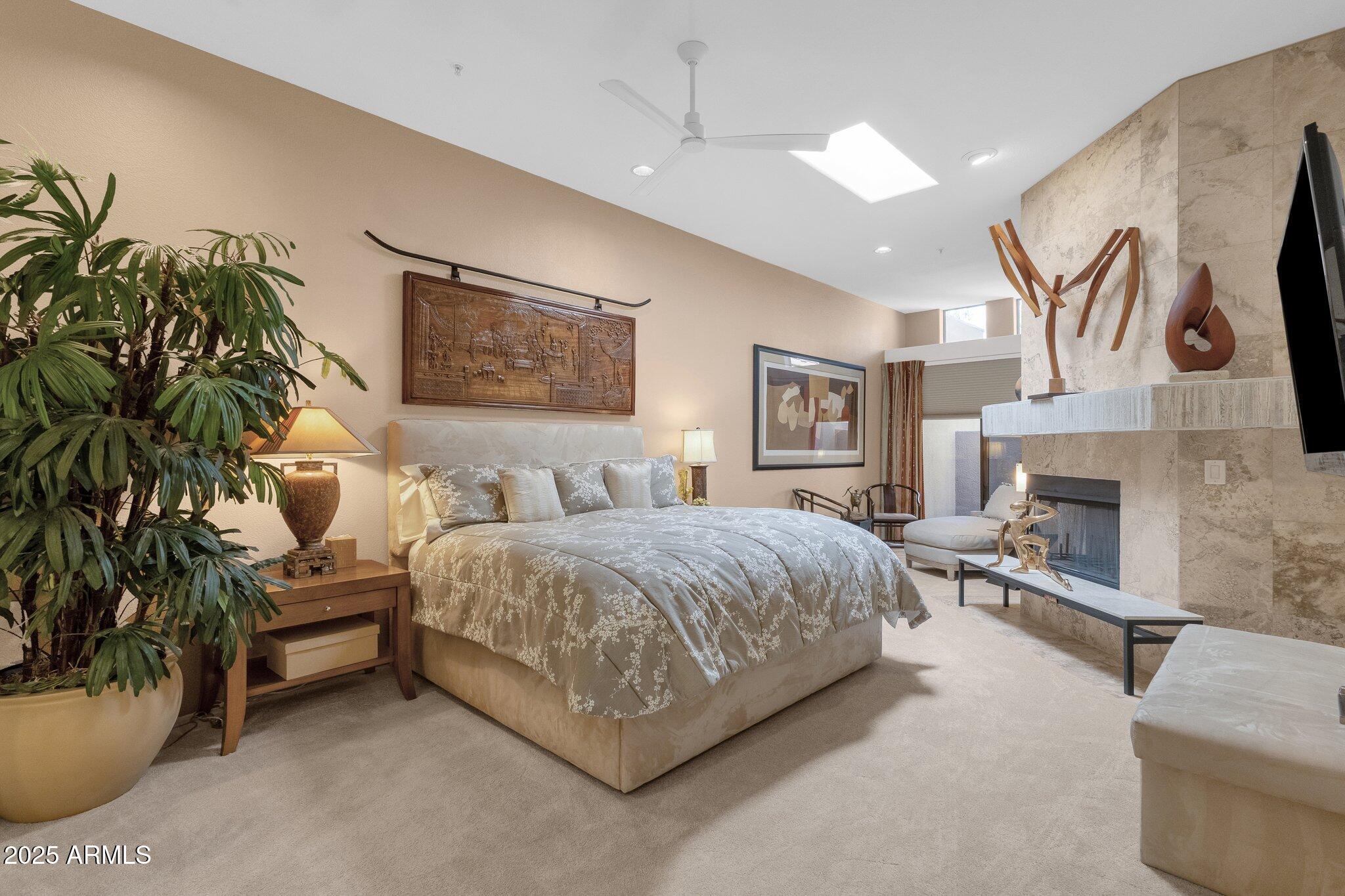 7740 East Gainey Ranch Road, Unit 36 Scottsdale, AZ 85258 - Photo 19 of 54 a spacious bedroom with a bed a couch and paintings on the wall