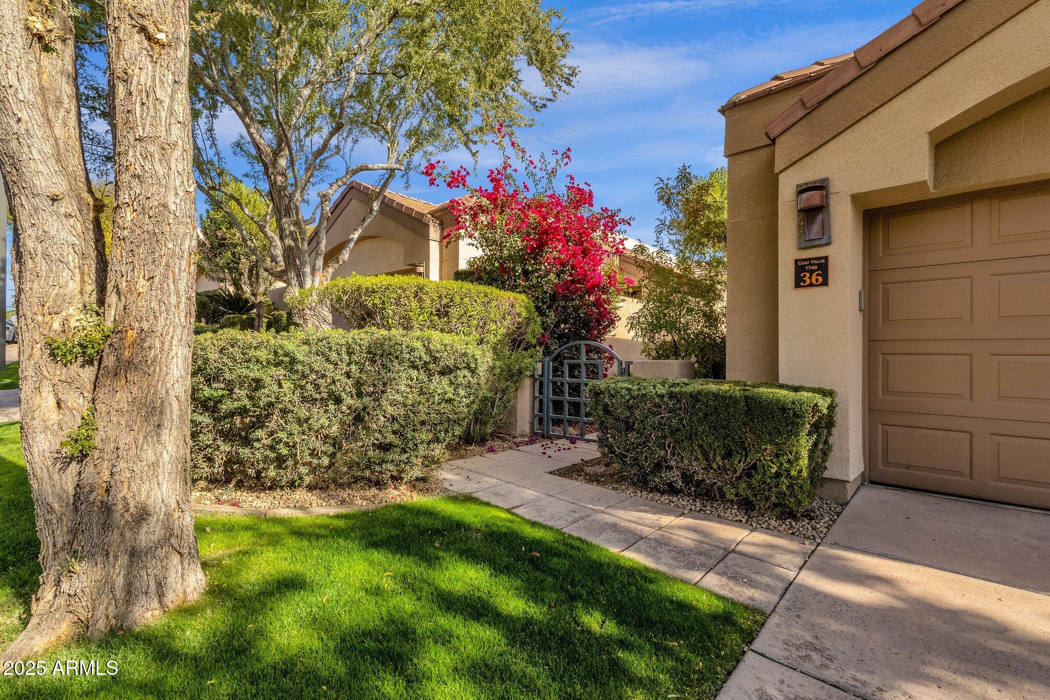 7740 East Gainey Ranch Road, Unit 36 Scottsdale, AZ 85258 - Photo 2 of 54 a front view of a house with a garden