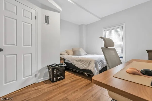 a bedroom with two beds and wooden floor