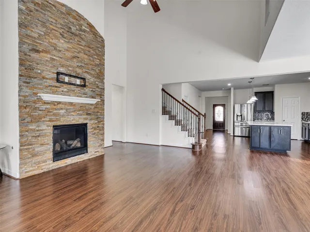 a view of a livingroom with wooden floor and a fireplace