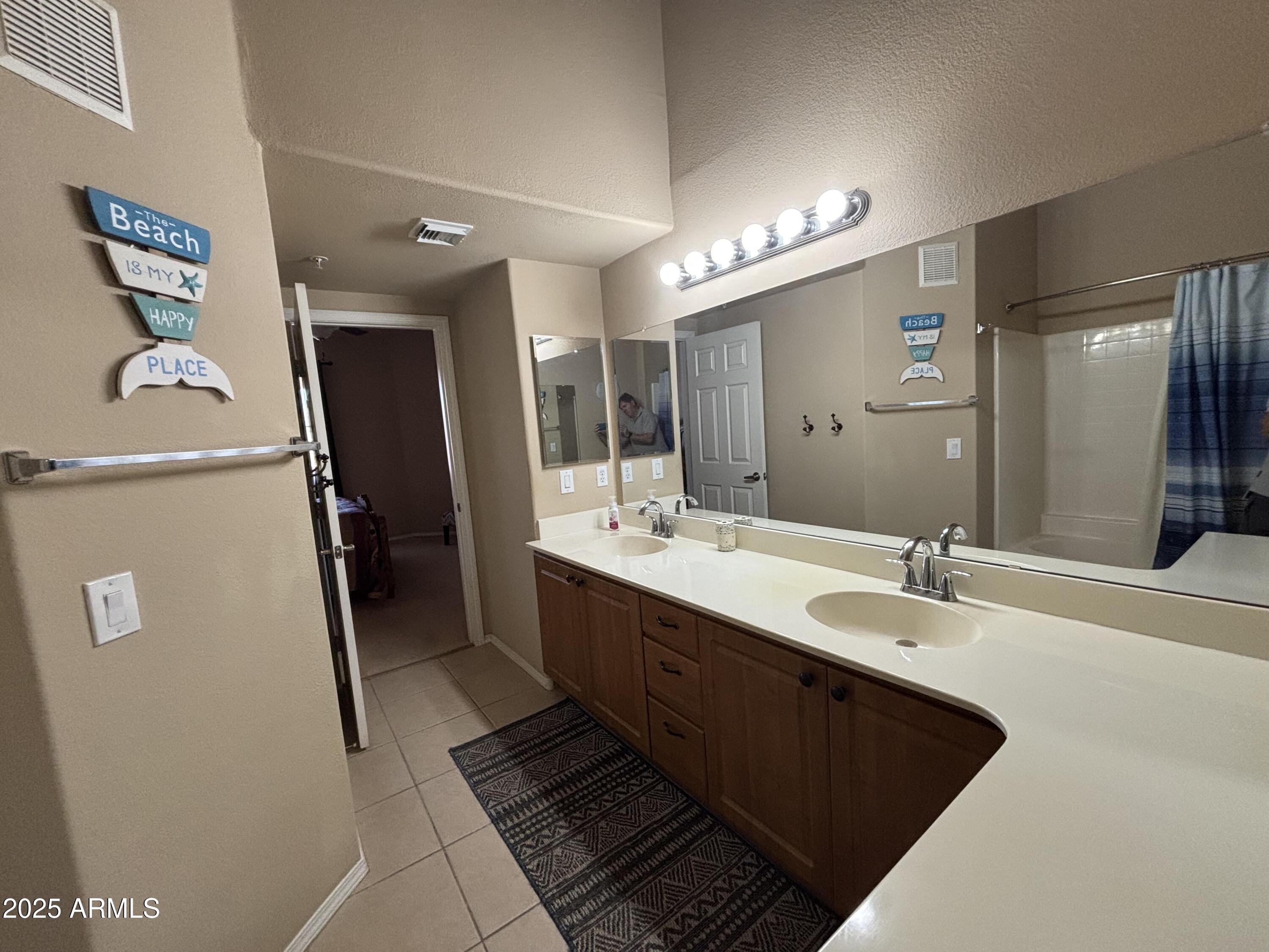 10136 East Southern Avenue, Unit 2048 Mesa, AZ 85209 - Photo 16 of 23 a spacious bathroom with a double vanity sink a mirror and a shower