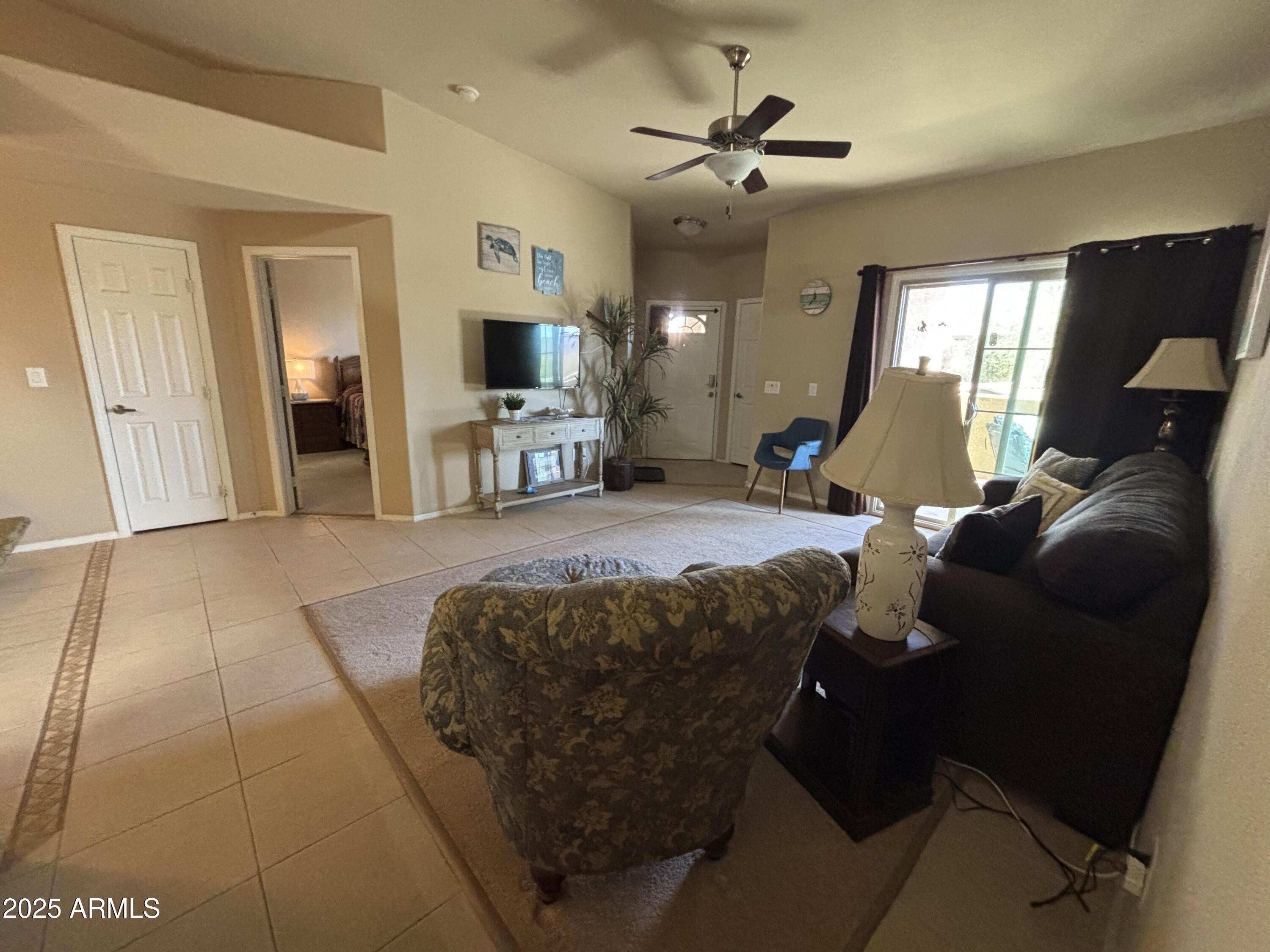 10136 East Southern Avenue, Unit 2048 Mesa, AZ 85209 - Photo 2 of 23 a living room with furniture and a flat screen tv