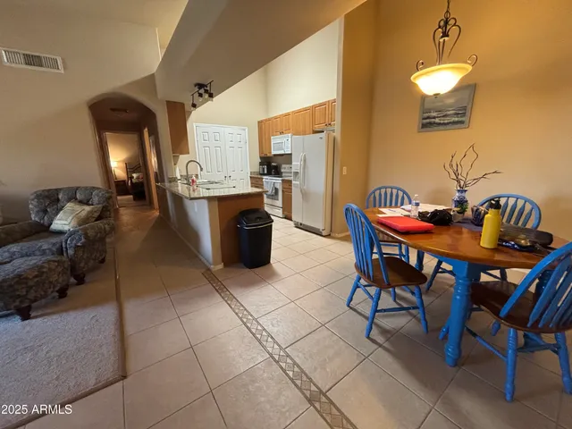 a living room with stainless steel appliances furniture a rug and a kitchen island
