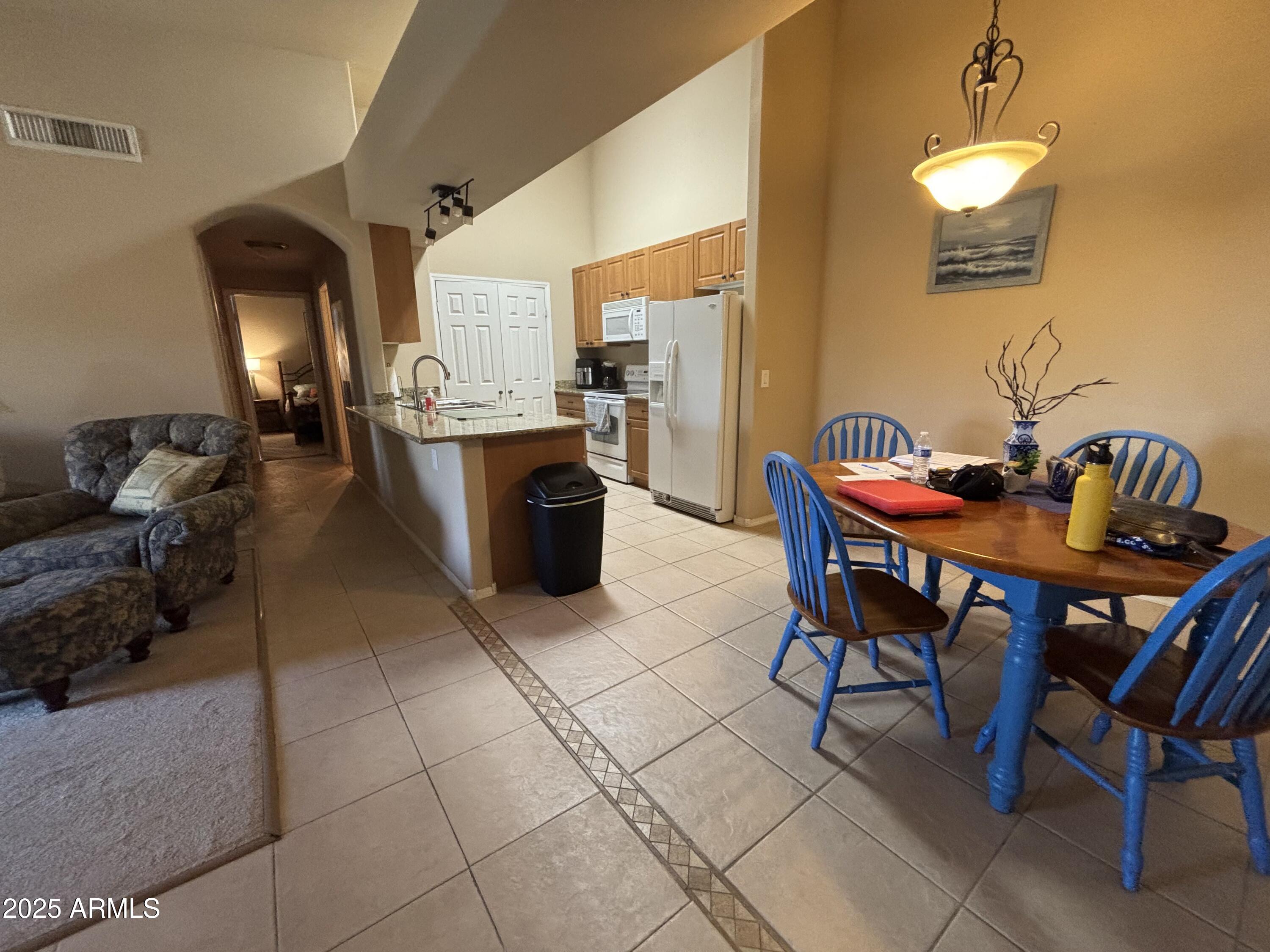 10136 East Southern Avenue, Unit 2048 Mesa, AZ 85209 - Photo 4 of 23 a view of a dining room with furniture and chandelier