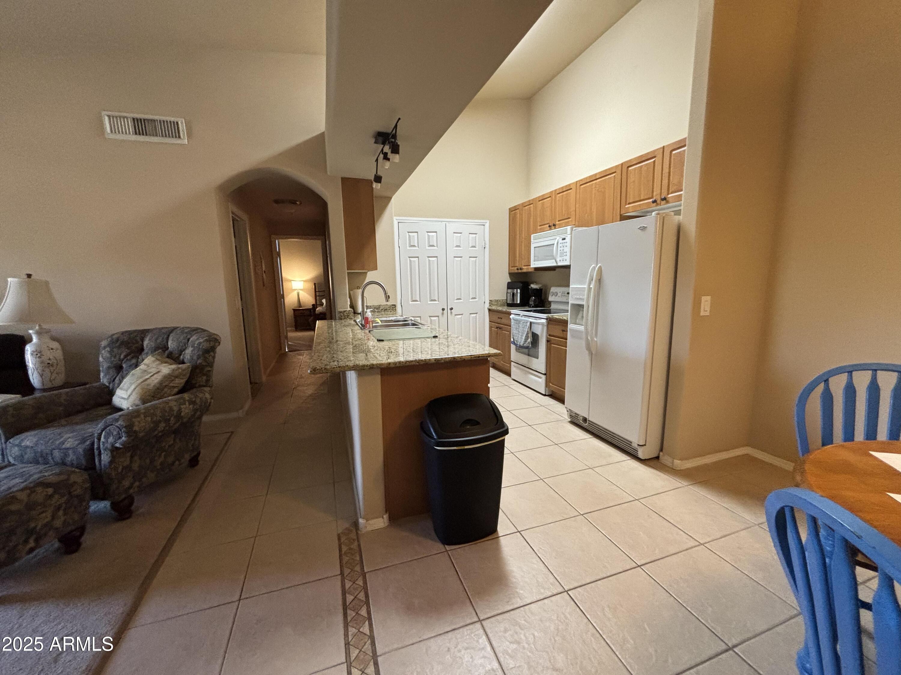 10136 East Southern Avenue, Unit 2048 Mesa, AZ 85209 - Photo 5 of 23 a living room with stainless steel appliances furniture a rug and a kitchen island
