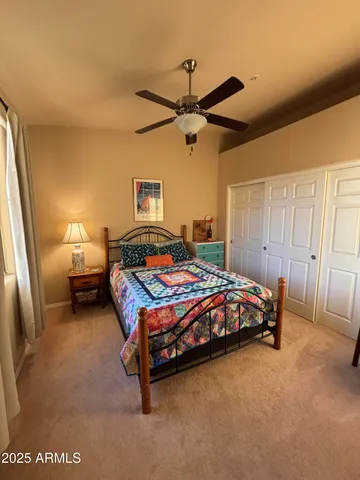 a bedroom with a bed and a lamp on dresser