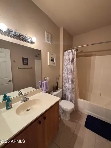 a bathroom with a sink a toilet a mirror and shower