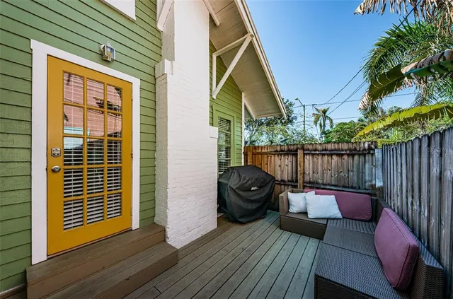 a balcony with wooden floor table and chairs