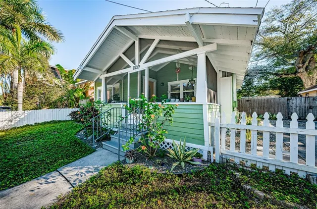 a view of a house with brick walls and a yard with plants