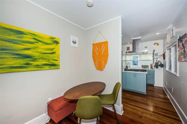a kitchen with stainless steel appliances kitchen island wooden cabinets dining table and chair