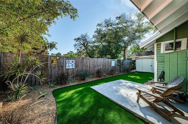 a view of a backyard with wooden fence and a bench