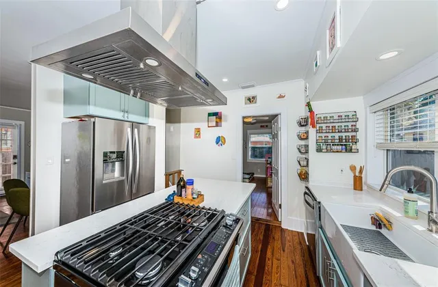 a kitchen with stainless steel appliances granite countertop a refrigerator and a stove top oven