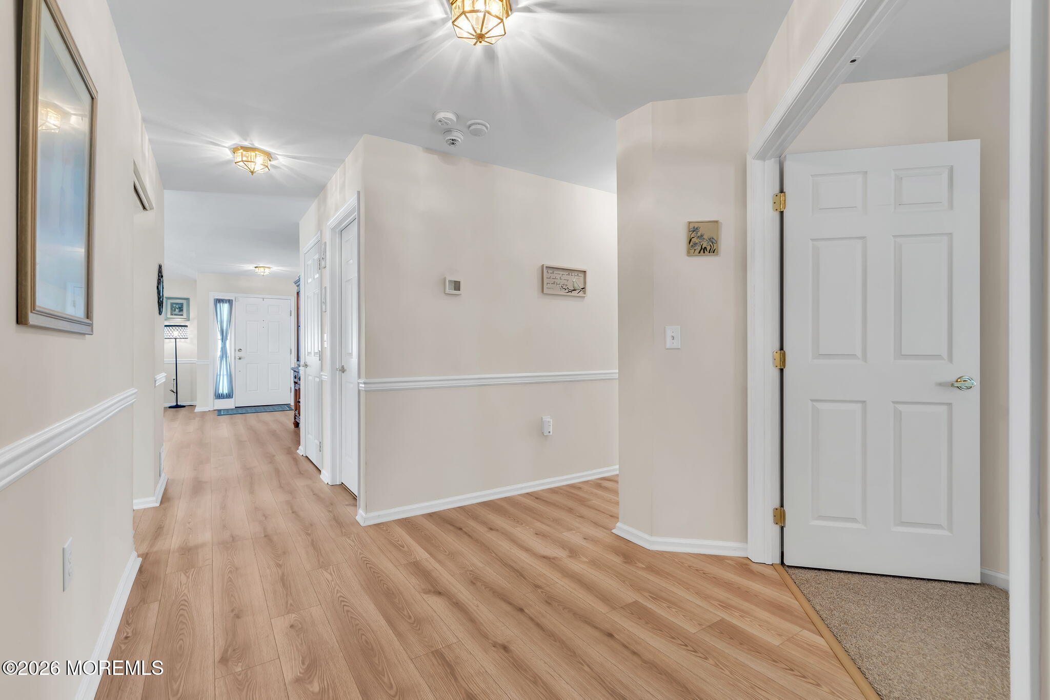 10 Congressional Road Jackson, NJ 08527 - Photo 34 of 72 a view of a hallway with wooden floor and a chandelier