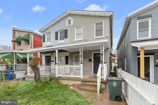 a view of a house with wooden fence and a porch