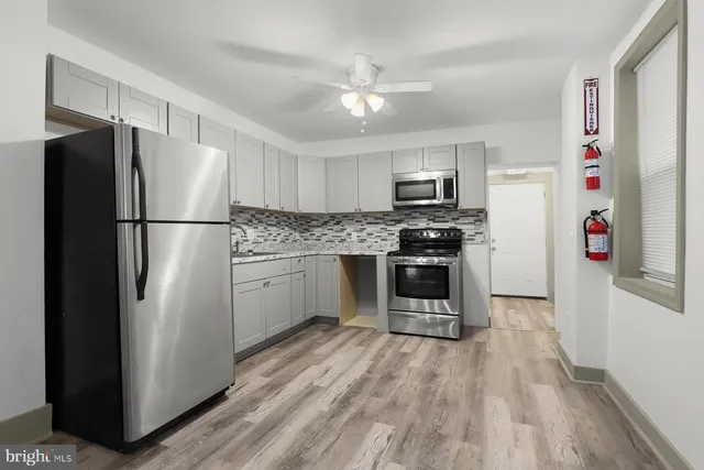 a kitchen with a refrigerator and a stove top oven