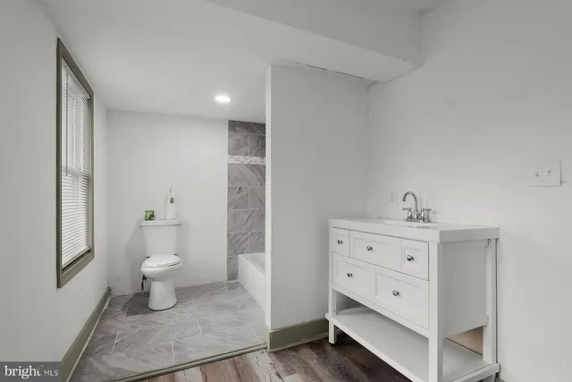 a bathroom with a sink a toilet and a mirror
