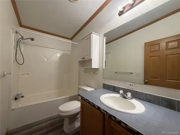 a bathroom with a sink toilet tub vanity and shower