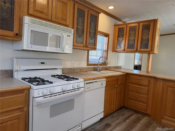 a kitchen with cabinets appliances a sink and a window