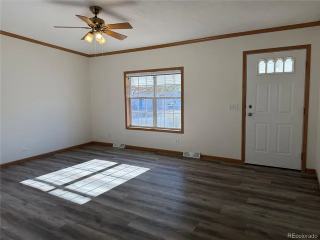 a view of an empty room window and wooden floor