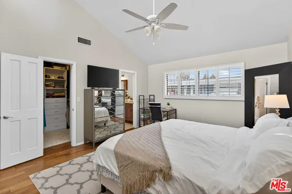 a large bedroom with a bed and a flat screen tv