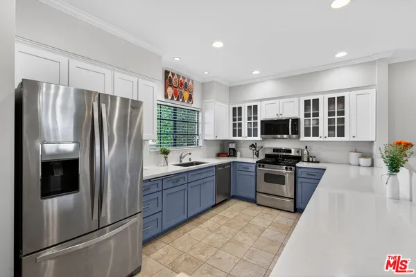 a kitchen with stainless steel appliances granite countertop a refrigerator stove and sink
